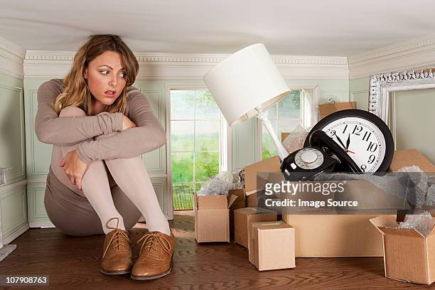 young woman with box of objects in small room - box trap stock pictures, royalty-free photos & images