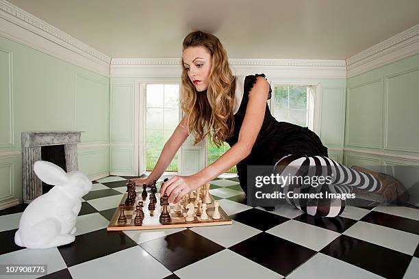 young woman playing chess with rabbit - giant rabbit photos et images de collection