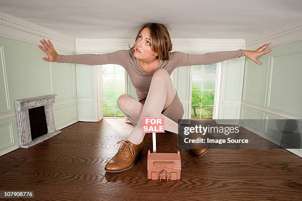 young woman in small house with model of house for sale - claustrophobia stock pictures, royalty-free photos & images