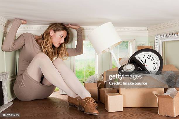 young woman with box of objects in small room - box trap stock pictures, royalty-free photos & images