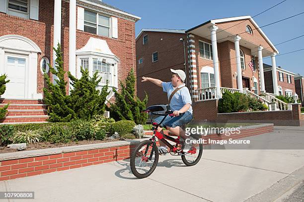 paperboy with bike throwing newspaper - newspaper boy stockfoto's en -beelden
