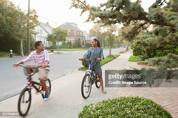 brother and sister on bicycles - queens stockfoto's en -beelden