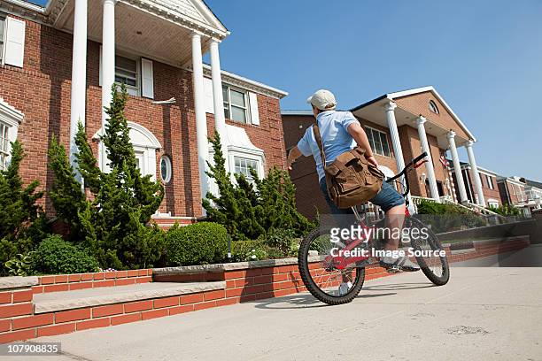 paperboy mit fahrrad werfen zeitung - zeitungsausträger stock-fotos und bilder
