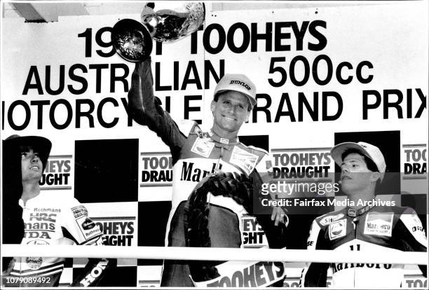 On The Winners Podium....Wayne Rainey salutes crowd as Mike Doohan &amp; John Kocinski. April 7, 1991. .