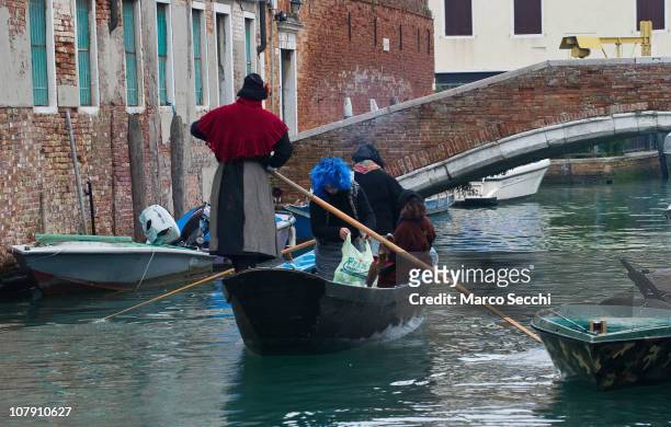 Participants dressed in costumes row a venetian boat to the Befana Regata on January 6, 2011 in Venice, Italy. In Italian folklore, Befana is an old...