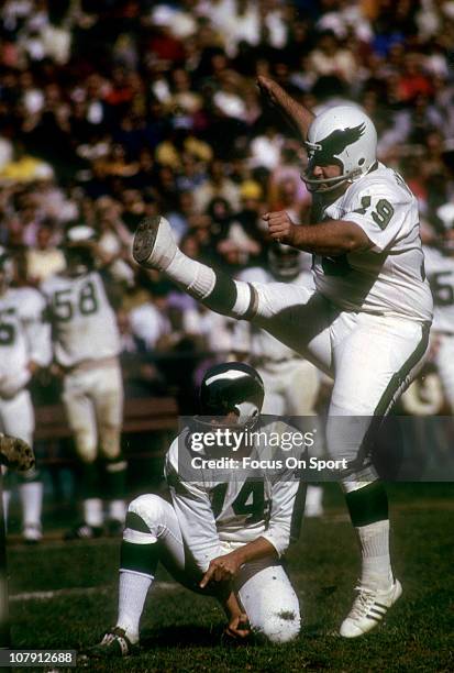 Kicker Tom Dempsey of the Philadelphia Eagles kicks a field goal with quarterback Pete Liske doing the holding during an NFL football game circa...