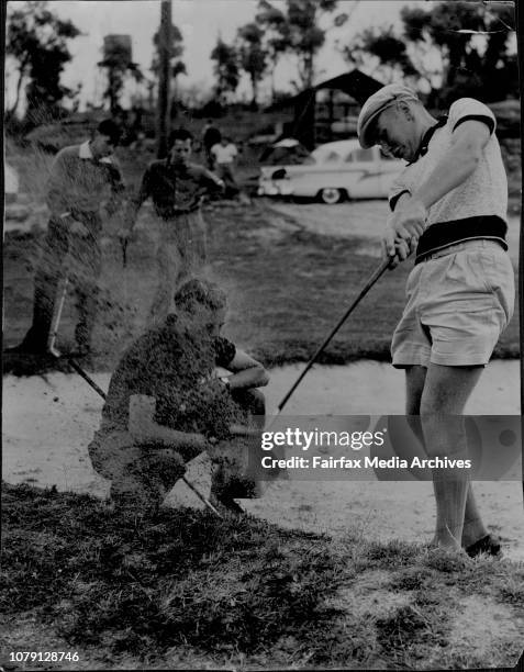Gary Wells of Dapto, explodes out of a bunker at Monash Park course and showers amateur golfer Bruce Devlin with sand and divots. Devlin crouched for...