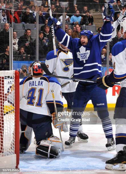 Colby Armstrong of the Toronto Maple Leafs celebrates a first-period goal in front of Jaroslav Halak of the St. Louis Blues during game action...