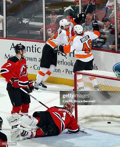 Scott Hartnell of the Philadelphia Flyers scores at 15:46 of the second period against Johan Hedberg of the New Jersey Devils and is joined by Danny...