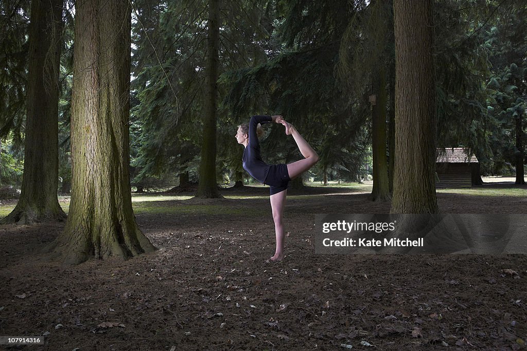 Young woman practicing yoga in woodland