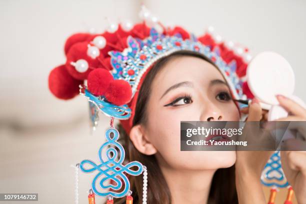 close-up of a chinese female opera actress is doing the make up - chinese opera makeup stock pictures, royalty-free photos & images