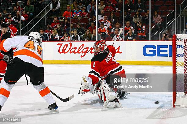 Danny Briere of the Philadelphia Flyers puts the puck past goaltender Johan Hedberg of the New Jersey Devils for a goal during the game at the...
