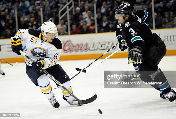 Tyler Ennis of the Buffalo Sabres looks to get control of the puck in front of Douglas Murray of the San Jose Sharks in the third period of an NHL...