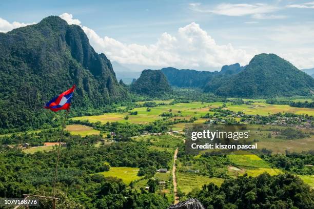 aerial view of rice fields surrounded by mountains in vang vieng during day, laos - laos vientiane stock-fotos und bilder