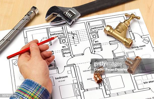 plumber with house plans - idraulico foto e immagini stock