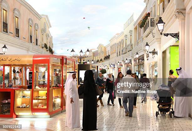 Qatari people in their traditional clothes called dishdasha and abaya are pictured at Villagio shopping mall on December 29, 2010 in Doha, Qatar. The...