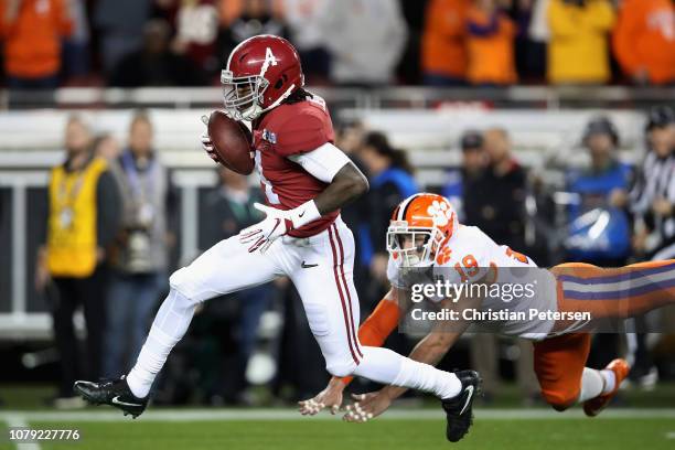 Jerry Jeudy of the Alabama Crimson Tide scores a first quarter touchdown reception past Tanner Muse of the Clemson Tigers in the CFP National...