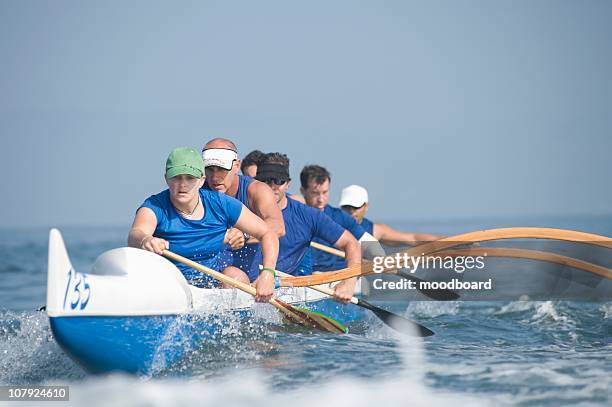 outrigger canoeing team on water - outrigger stock pictures, royalty-free photos & images