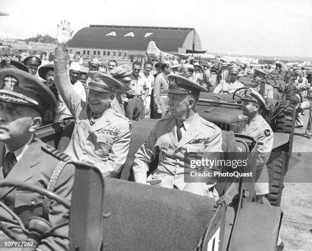 American General George C. Marshall rodes with General Dwight Eisenhower , who waves to spectators from a jeep upon his return to the US after the...