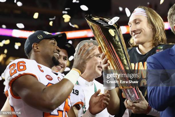 Adam Choice and Trevor Lawrence of the Clemson Tigers celebrate with the trophy after their teams 44-16 win over the Alabama Crimson Tide in the CFP...