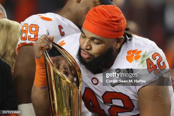 Christian Wilkins of the Clemson Tigers celebrates with the trophy after his teams 44-16 win over the Alabama Crimson Tide in the CFP National...