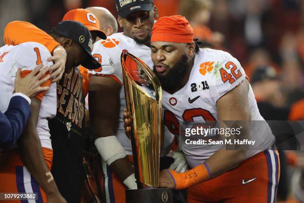 Christian Wilkins of the Clemson Tigers celebrates with the trophy after his teams 44-16 win over the Alabama Crimson Tide in the CFP National...