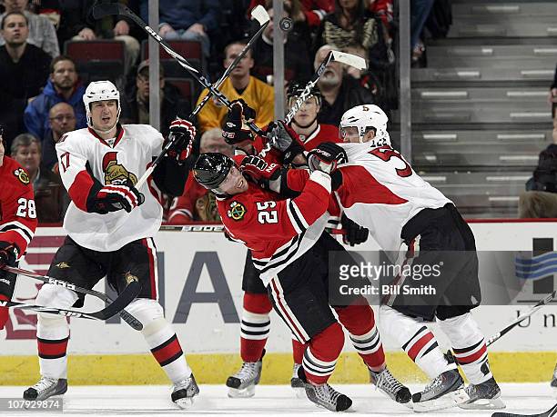 Brian Lee of the Ottawa Senators pushes into Viktor Stalberg of the Chicago Blackhawks as teammate Filip Kuba watches from behind on January 7, 2011...