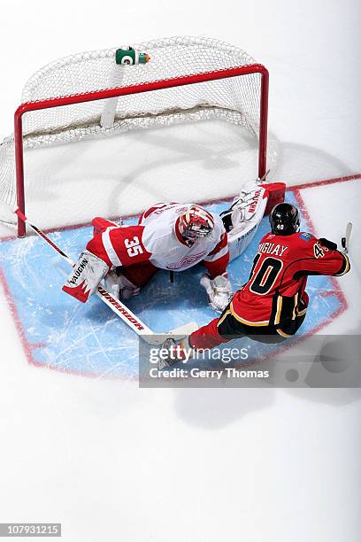 Alex Tanguay of the Calgary Flames tries to deke around Jimmy Howard of the Detroit Red Wings during a shootout on January 07, 2011 at the Scotiabank...