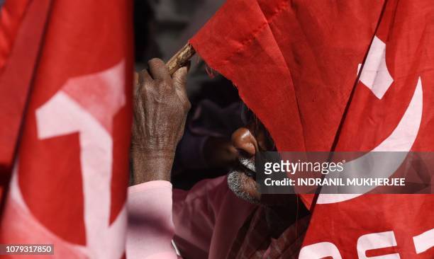 An Indian activist from the Centre of Indian Trade Unions , which is politically aligned with the Communist Party of India , uses the party flag to...