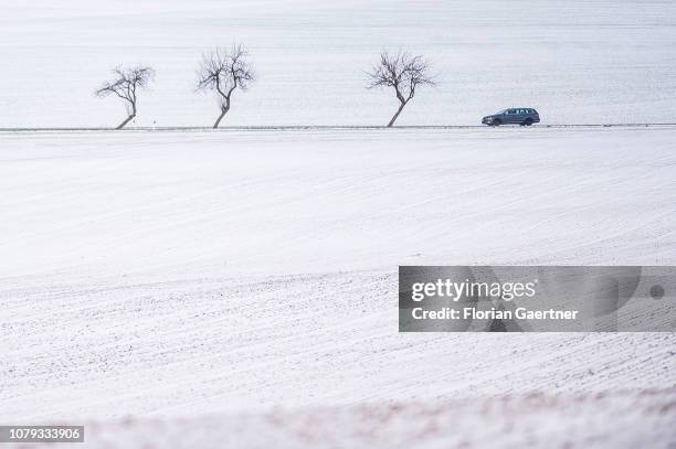 Car between snow covered fields is pictured near the german-polish-czech border triangle at the Zittauer Mountain on January 02, 2019 in Zittau,...