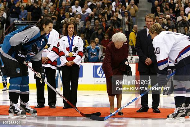 Britain's Queen Elizabeth II drops the ceremonial puck prior to the Vancouver Canucks preseason game against the San Jose Sharks 06 October 2002, in...
