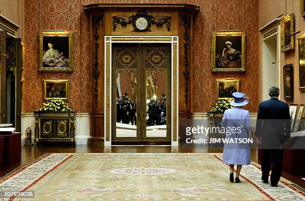 President George W. Bush walks through the Queen's Gallery at Buckingham Palace with Britain Queen Elizabeth II 19 November 2003 during his state...