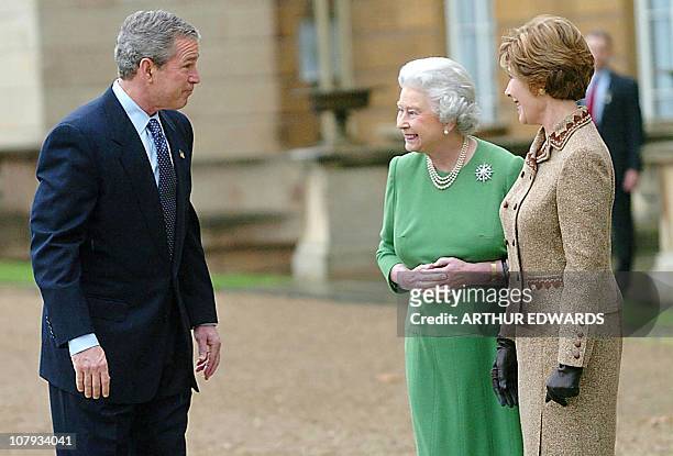 President George W. Bush bids farewell to Britain's Queen Elizabeth II as his wife Laura looks on at Buckingham Palace 21 November 2003, before...