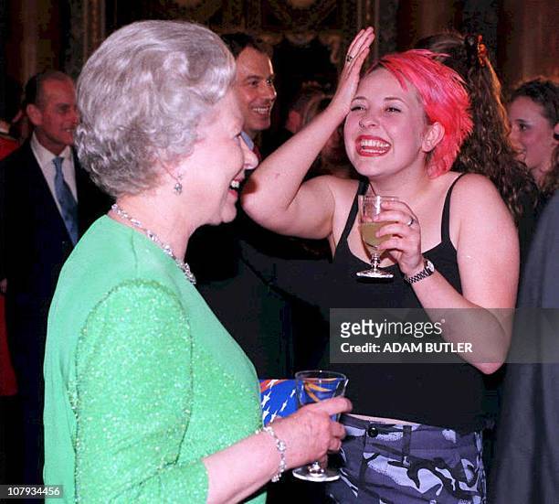 Britain's Queen Elizabeth II chats with Julie Thompson , a vocalist with the first rock band to perform at Buckingham Palace 03 April. The...