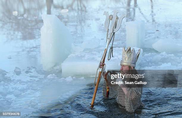 An ice swimming enthusiast dressed as Neptune takes to the frigid waters of Orankesee lake during the 27th annual "Winter Swimming in Berlin" on...