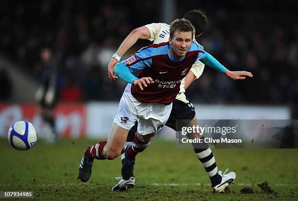 Andrew Wright of Scunthorpe United is tackled by Diniyar Bilyaletdinov of Everton during the FA Cup sponsored by Eon 3rd round match between...