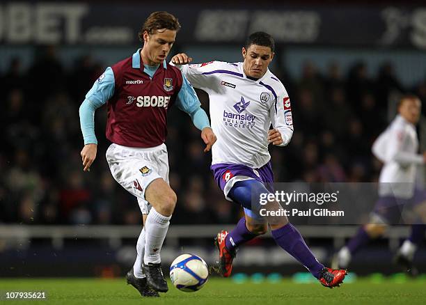 Scott Parker of West Ham United holds off the challenge by Nathan Doyle of Barnsley during the FA Cup sponsored by E.O.N 3rd Round match between West...