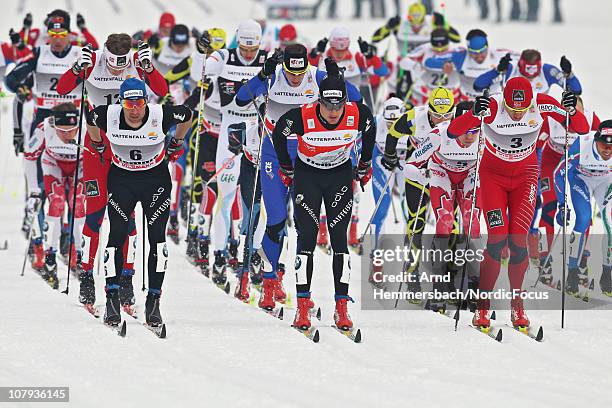 Curdin Perl of Switzerland, Dario Cologna of Switzerland, Petter Northug of Norway compete during the mass start men event for the FIS Cross Country...