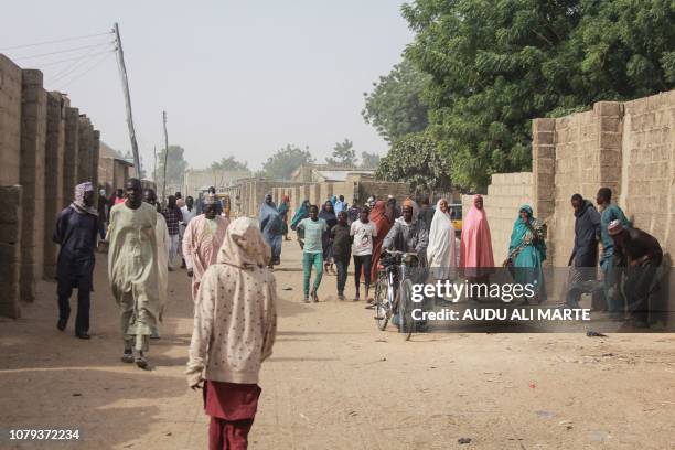 People walk in the streets of the Sajeri village on the outskirts of the Borno state capital, Maiduguri, on January 8, 2019 as they gather for the...