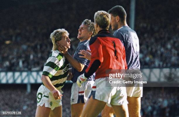 Celtic striker Frank McAvennie is held by the throat by Rangers defender Graham Roberts as goalkeeper Chris Woods and Terry Butcher look on, Butcher,...