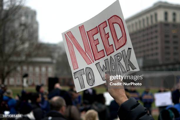 Furloughed federal workers, joined by elected officials, hold up sings to protest the federal government shutdown during a non-partisan rally at...