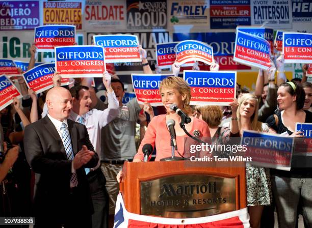 Rep. Gabrielle Giffords speaks on election night at Democratic Election Headquarters as her husband Mark Kelly applauds at the Tucson Marriott...