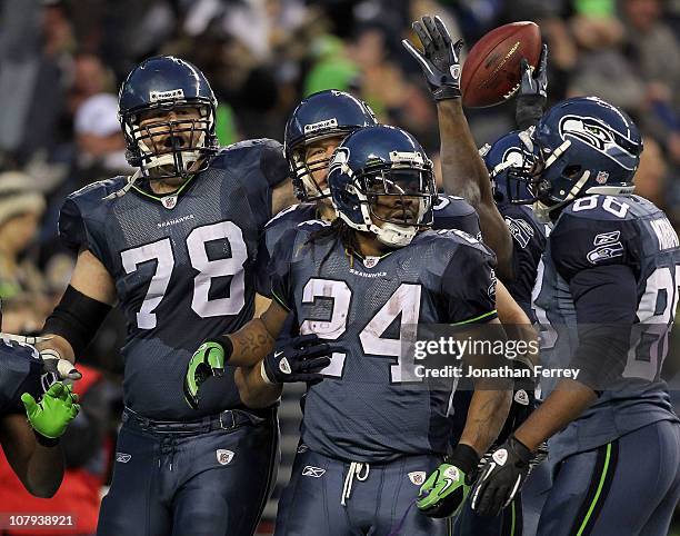 Running back Marshawn Lynch of the Seattle Seahawks celebrates with his teammates his 67-yard touchdown run in the fourth quarter against the New...