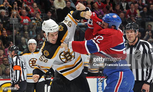 Travis Moen of the Montreal Canadiens and Adam McQuaid of the Boston Bruins fight during the NHL game on January 8, 2011 at the Bell Centre in...
