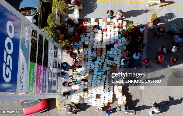 People buy gasoline at a gas station in Morelia, Michoacan state, one of several Mexican states where shortages have been reported, on January 8,...