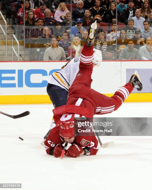 Oliver Ekman-Larsson of the Phoenix Coyotes goes head first into the ice over Steve Montador of the Buffalo Sabres on January 8, 2011 at Jobing.com...