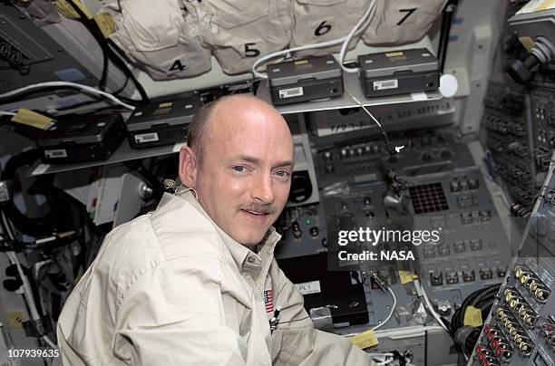 In this handout image provided by NASA, astronaut Mark E. Kelly, STS-108 pilot, stands at the aft flight deck control panel on the Space Shuttle...