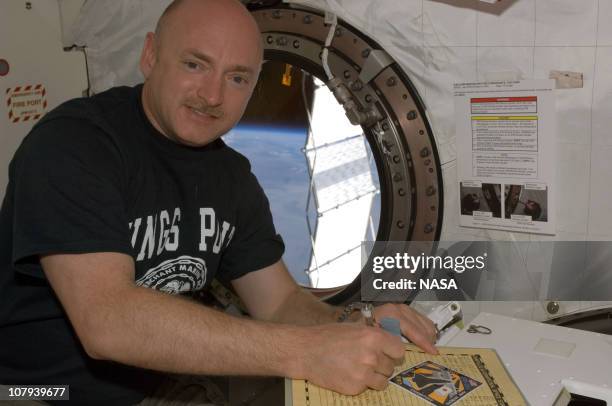 In this handout image provided by NASA, astronaut Mark E. Kelly, STS-124 commander, makes an entry in the International Space Station ship's log in...