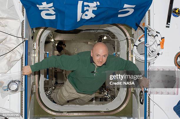 In this handout image provided by NASA, astronaut Mark E. Kelly, STS-124 commander, floats in the hatch between the Harmony node and the newly...