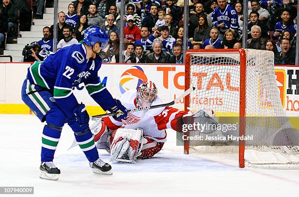 Jimmy Howard of the Detroit Red Wings makes a save on Daniel Sedin of the Vancouver Canucks during their game at Rogers Arena on January 8, 2011 in...